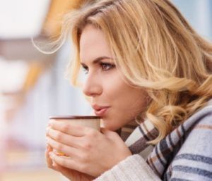 Mortgage After Divorce or Separation: What Are Your Options? A woman warms up with a hot drink and she blows it to cool it down