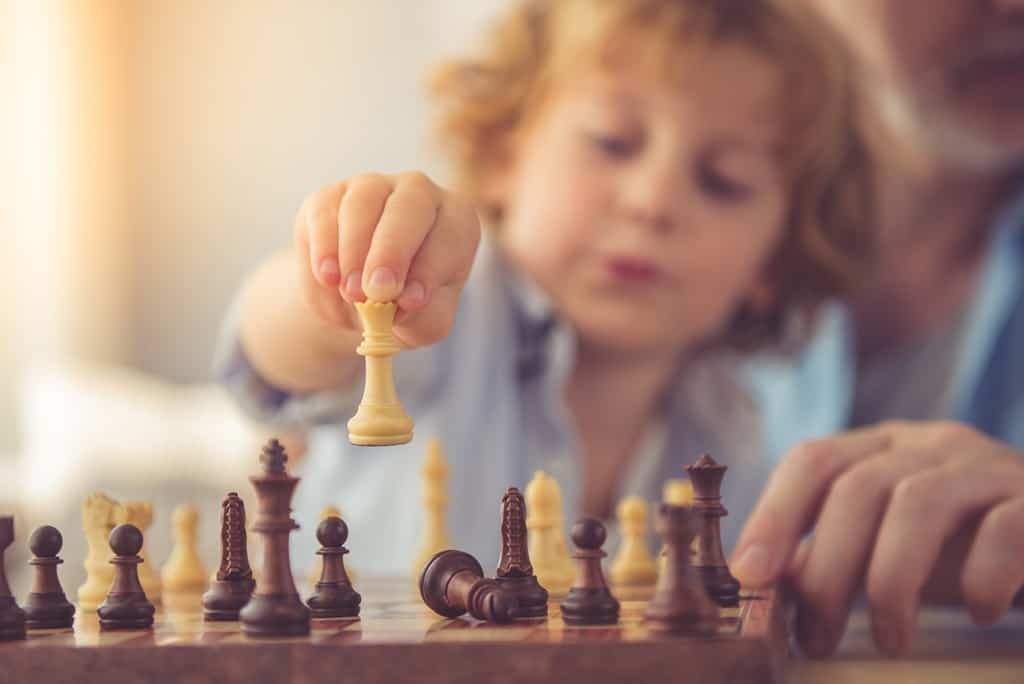 A young child plays chess