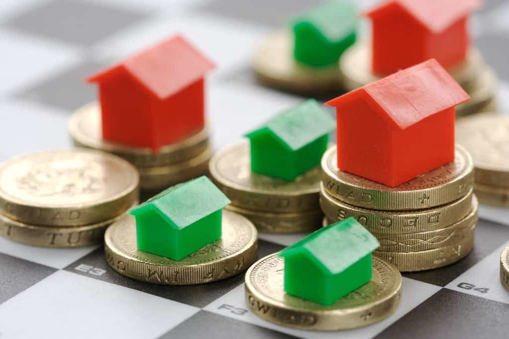 Monopoly houses and hotels on stacked pound coins to show the change in stamp duty for first time buyers