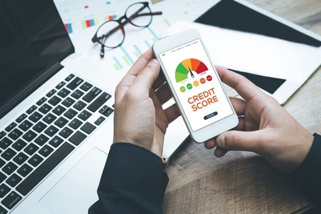 A man holding a phone as he checks his credit score