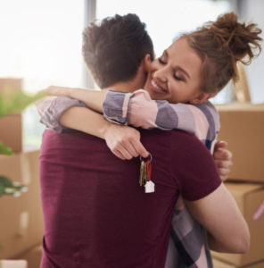 Happy couple with keys of new apartment