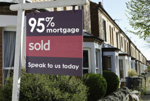 English suburban house with ‘sold’ sign.