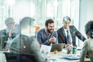 Cheerful businessman talking to his colleagues in the office.