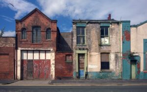 Navigating the Complex World of Development Finance derelict houses and abandoned commercial property on a residential street with boarded up windows and decaying crumbling walls